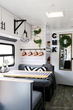 the interior of a mobile home with white walls and wood flooring is decorated in black and white