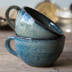 two blue cups sitting on top of a wooden table