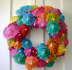 a wreath made out of umbrellas hanging on a door