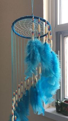 a blue dream catcher hanging from a window sill