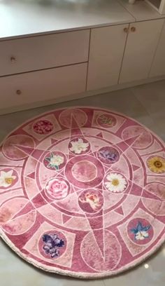 a round rug with flowers on it in the middle of a kitchen countertop next to cabinets