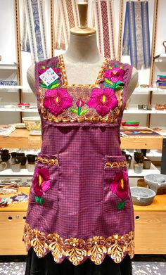 a mannequin wearing a purple dress with pink flowers on it's chest