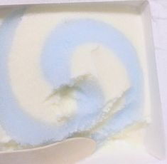 an ice cream dish with blue swirl on top and a spoon in the bowl next to it