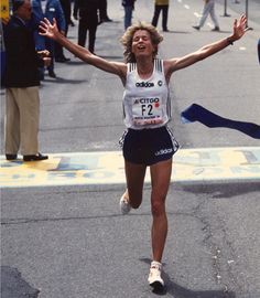 a woman running in a marathon with her arms outstretched