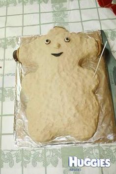 there is a cake that looks like a bear on the sheeted paper with a knife and fork in it