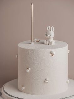 a white cake topped with a rabbit figurine