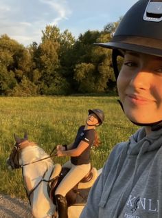 a young woman riding on the back of a white horse next to a small boy