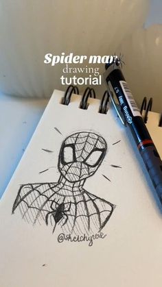 a spider man drawing on paper next to a marker and some black pens with the words spiderman drawn in it