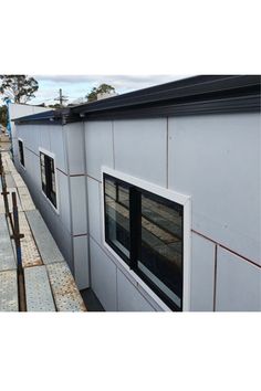 the side of a building that is being built with metal siding and windows on it