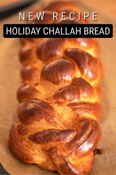 a long loaf of bread sitting on top of a wooden cutting board with the words new recipe holiday challah bread