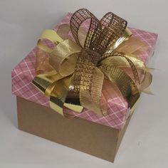 a pink and gold wrapped gift box with ribbon