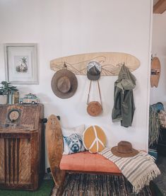 a room filled with lots of hats hanging on the wall next to a bench and table