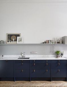 a kitchen with blue cabinets and white counter tops in the middle of an open floor plan