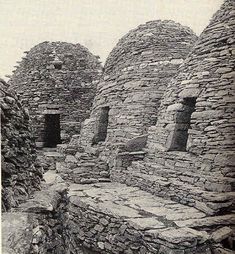 an old black and white photo of some stone buildings in the middle of nowhere,