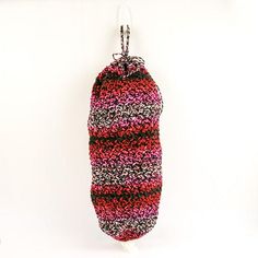 an oven mitt hanging from a hook on a white wall with a red and black pattern