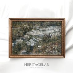 a painting hanging on the wall next to a white bedding with flowers in it