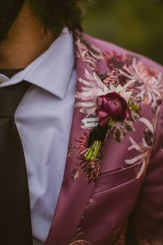 a man wearing a purple suit and flower boutonniere with a white shirt