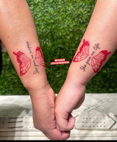 two people holding hands with red butterflies on their arms and the words love are written on them