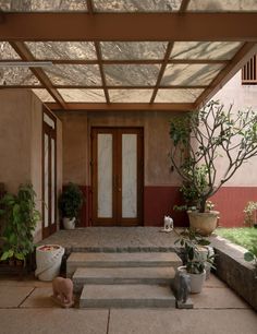 an entry way with plants and potted trees