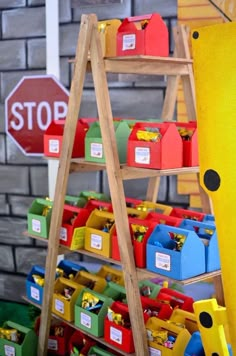 there is a ladder that has bins on it and a stop sign in the background