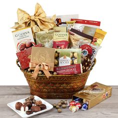 a basket filled with chocolates and candies on top of a wooden table next to a plate