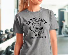 Let's Lift Each Other Up motivational gym t-shirt. This is an ultra comfy tee perfect for showing off your gains at the gym. Get two to match your gym buddy! Bring some motivation to everyone around you as you rock this uplifting message. Crop Top listing here: https://mamaandmoondesigns.etsy.com/listing/1752739415 Tank top listing here: https://mamaandmoondesigns.etsy.com/listing/1739569550 This product is made to order as soon as you place it! Please allow 2-5 business days for product to be s Gym Buddy, Gym Shirt, Gym Shirts, You Rock, T Shirt Funny, Matching Shirts, Comfy Tees, Workout Shirts, Workout Clothes