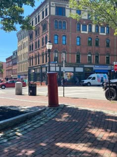 a motorcycle parked on the side of a road next to a tall red brick building