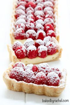 raspberry cheesecake tarts with powdered sugar on top are ready to be eaten