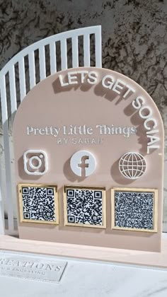 a white chair sitting on top of a table next to a plaque that says let's get social pretty little things