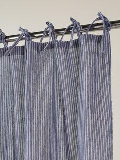 blue and white striped curtains hanging from a metal rod