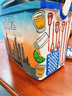 a painted basket sitting on top of a wooden table