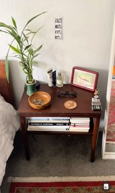 a wooden table topped with books and a potted plant next to a door way