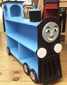 there is a blue shelf with a black and white thomas the tank engine on it