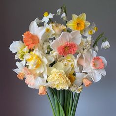 a vase filled with lots of white and yellow flowers