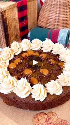 a chocolate cake sitting on top of a table next to two heart - shaped cookies