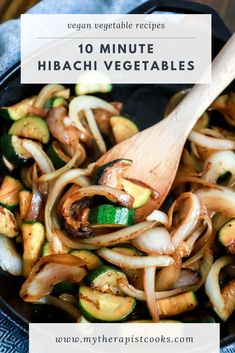 a skillet filled with stir fry vegetables on top of a blue towel next to a wooden spoon