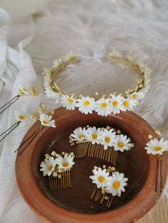 daisies and combs are placed in a clay bowl