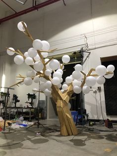 a large light fixture in the shape of a tree with white balls hanging from it's branches