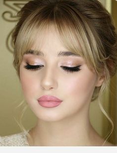 a woman with blonde hair and pink eyeshadow