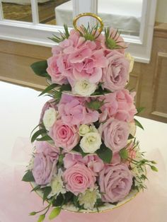 a three tiered cake with pink and white flowers