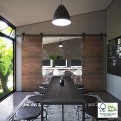 a dining room table and chairs in front of a brick wall with an open window