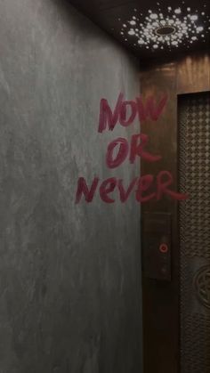 the words now or never are spray painted on the wall next to an elevator door