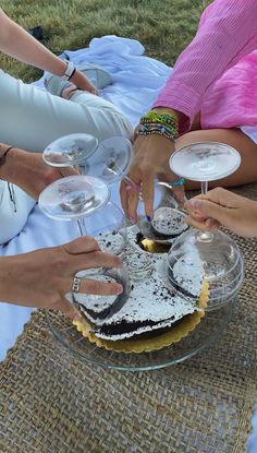 people are serving themselves wine and cake at an outdoor event