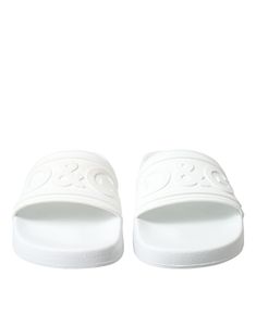 Step into luxury with these exquisite white logo embossed slides from the renowned house of Dolce & Gabbana. Impeccably crafted in Italy, these slides are perfect for those who seek elegance even in their casual wear. The wide strap design and molded footbed provide both supreme comfort and style, making these flats a summer essential for any fashion-forward wardrobe. Material: 100% Rubber Color: White Country of origin: Italy Logo details White Luxury Slides, Luxury White Slides, Italy Logo, Rubber Sandals, Denim Jacket Men, Ballerina Flats, Dolce & Gabbana, Watches Jewelry, Wide Straps