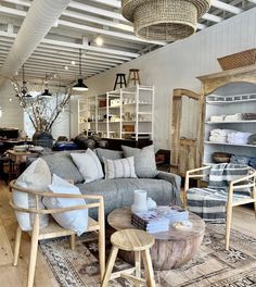 a living room filled with furniture and lots of pillows on top of a wooden floor