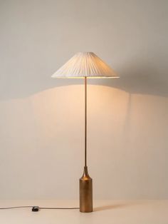 a table lamp with a white shade on it and a black cord plugged into the base