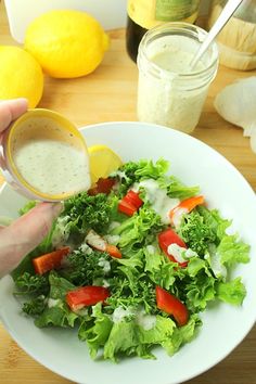 a person is pouring dressing into a salad