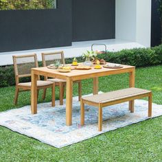 a wooden table and chairs sitting on top of a rug