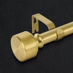 a close up of a door handle on a black surface with a gold colored finish