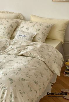 a bed with white sheets and pillows on top of it next to a book shelf